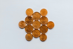 A neatly arranged group of euro coins, featuring 10-cent and 20-cent denominations, forming a circular pattern on a plain white background.