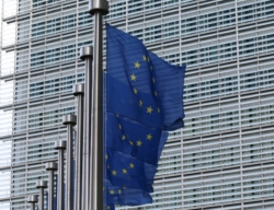 EU flags waving in front of the European Commission's Berlaymont building in Brussels.