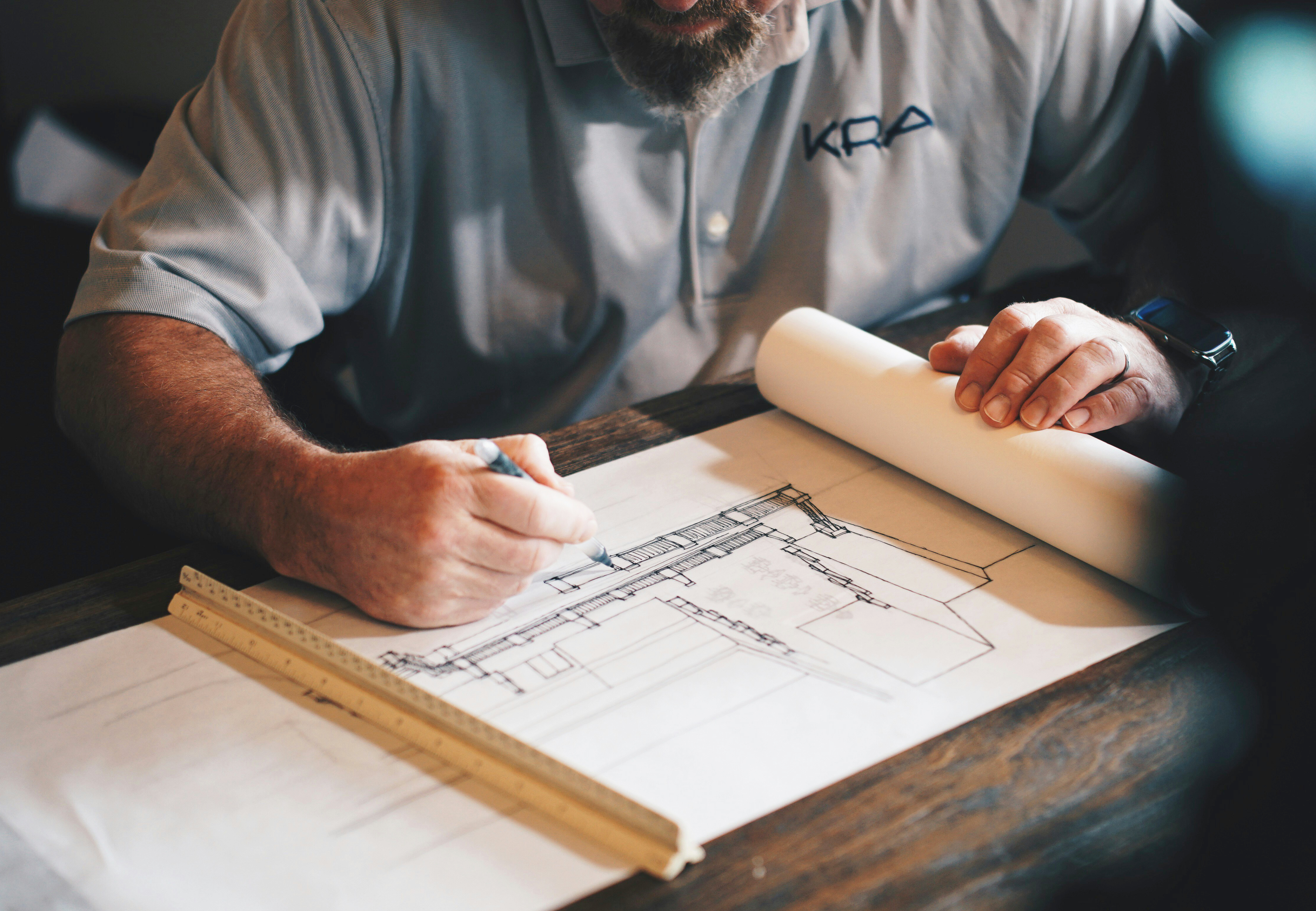 Man working on a house plan at a table.