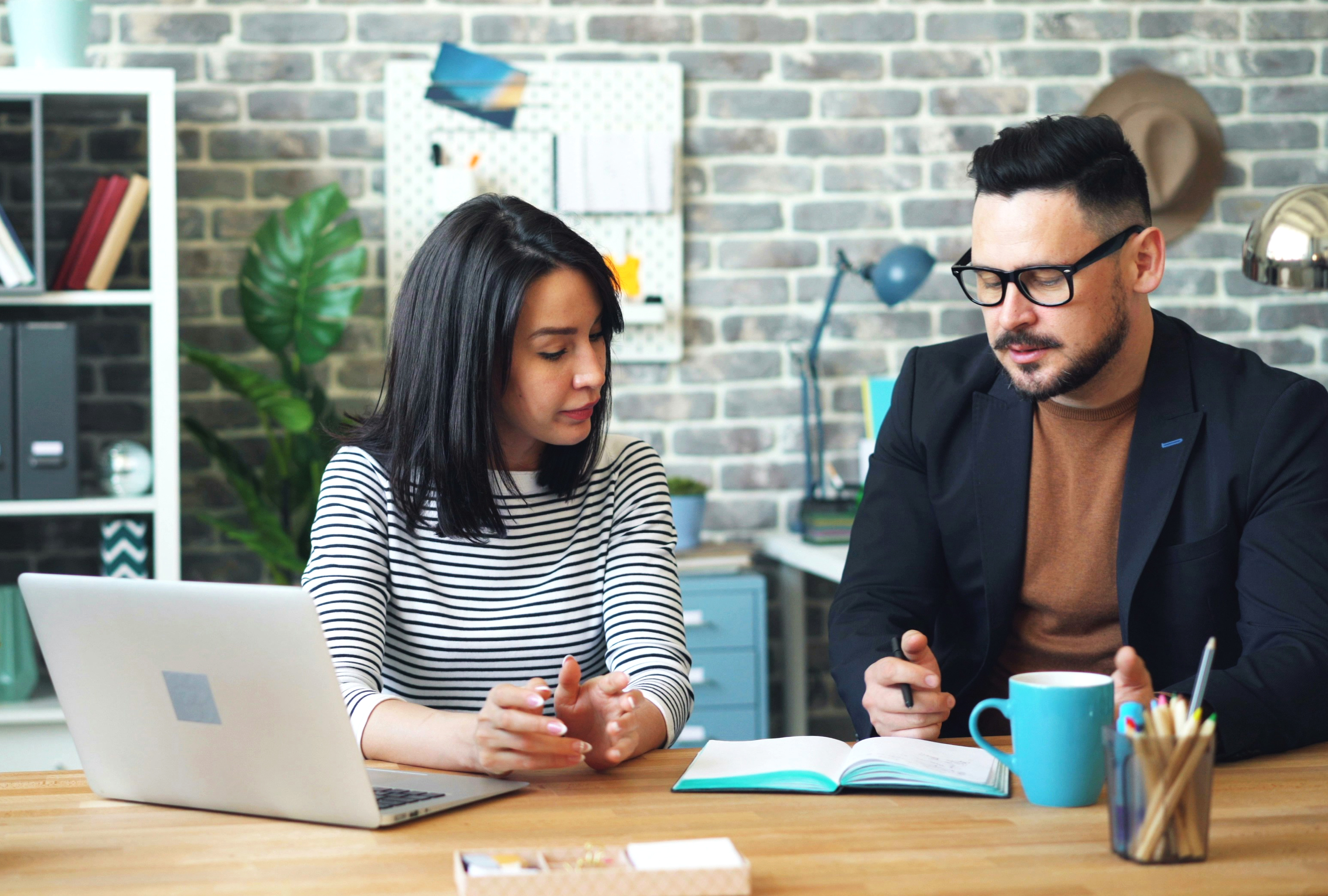 Colleagues reviewing subscriptions noted in a notebook.